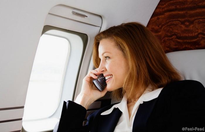 AW9FYG Businesswoman Using Cell Phone on Private Jet
