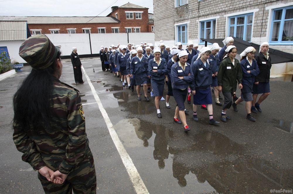 A female prison guard watches over a file of inmates in the yard of a prison camp in the Siberian city of Krasnoyarsk September 5, 2007.  REUTERS/Ilya Naymushin   (RUSSIA) - RTR1TGSS