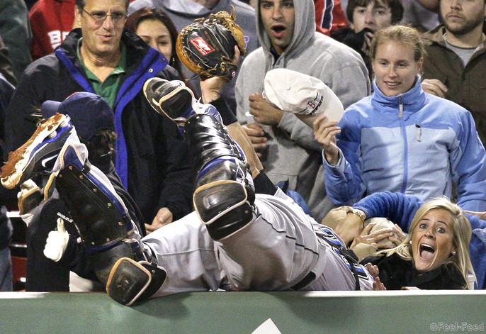Fans react as Toronto Blue Jays catcher Rod Barajas dives over the wall to catch a foul pop by Boston Red Sox's George Kottaras during the seventh inning in a baseball game at Fenway Park in Boston on Wednesday, Sept. 30, 2009. (AP Photo/Elise Amendola)