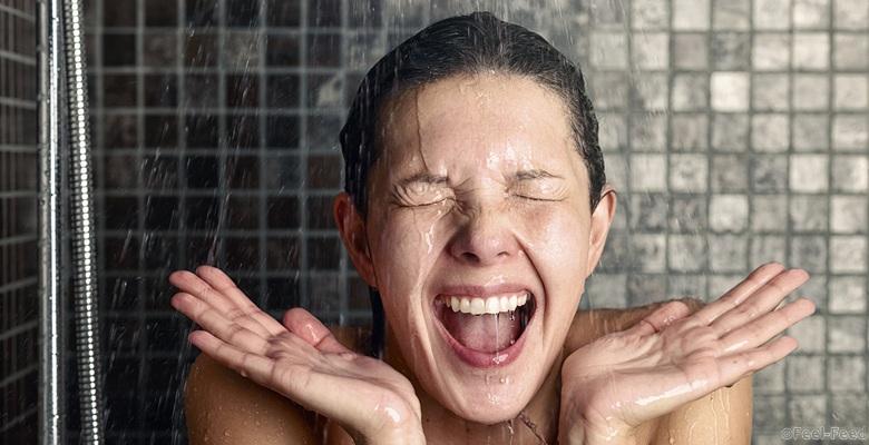 Young woman reacting in shock to hot or cold shower water as she stands under the shower head washing her hair eyes closed with her hands raised and mouth open; Shutterstock ID 245687524; PO: cold-shower-wake-up-stock-TODAY-tz-150422; Client: TODAY digital
