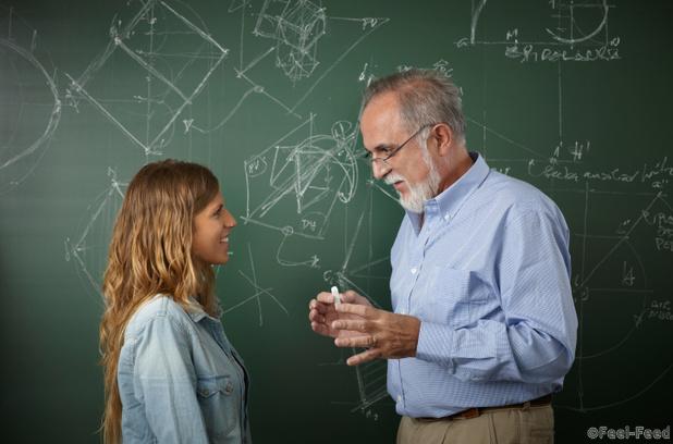 Teacher talking with young student in the classroom