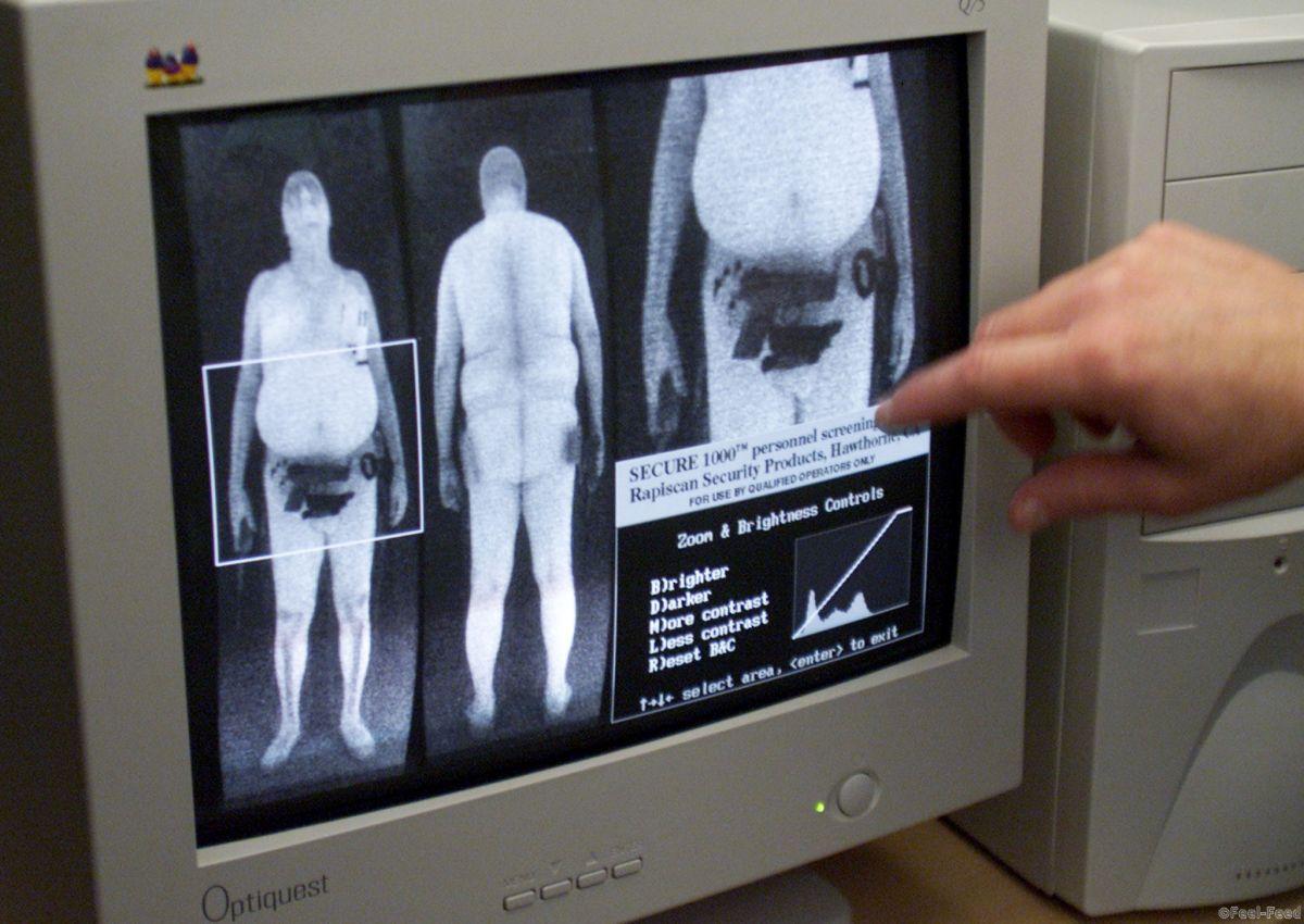 Bryan Allman of Rapidscan Security Products points to a scan revealing a hidden handgun during a demonstration of new screening devices at the Orlando International Airport in Orlando, Florida, March 14, 2002. The device shown is the Secure 1000, a low-energy full body x-ray scan. [Airport spokesperson Carolyn Fennell said the devices should be in use for passengers on a voluntary basis in several days. ] - RTXL5JU