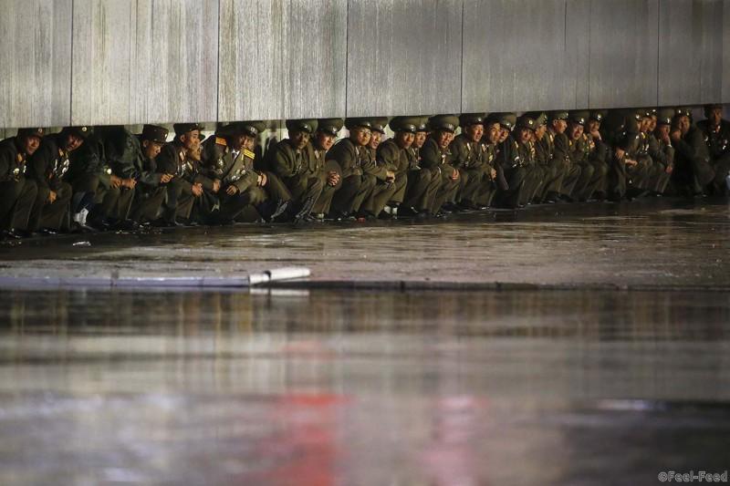 North Korean officers shield themselves from the rain after the parade celebrating the 70th anniversary of the founding of the ruling Workers' Party of Korea, in Pyongyang October 10, 2015. Isolated North Korea marked the 70th anniversary of its ruling Workers' Party on Saturday with a massive military parade overseen by leader Kim Jong Un, who said his country was ready to fight any war waged by the United States. REUTERS/Damir Sagolj