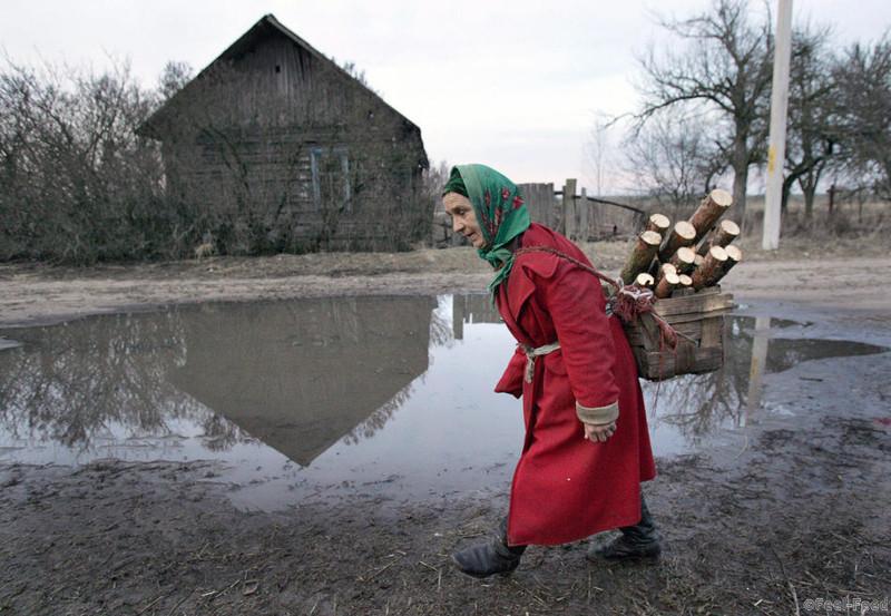 A local resident walks in the Belarussian village of Novoselki, just outside the 30km exclusion zone around the Chernobyl nuclear reactor, 07 April 2006. The 1986 Chernobyl disaster severely contaminated one quarter of Belarus' territory and tens of thousands of people were evacuated from their homes as radiation from Chernobyl spread throughout the area in April 1986. The 20th anniversary of the Chernobyl accident falls on 26 April 2006. AFP PHOTO / VIKTOR DRACHEV