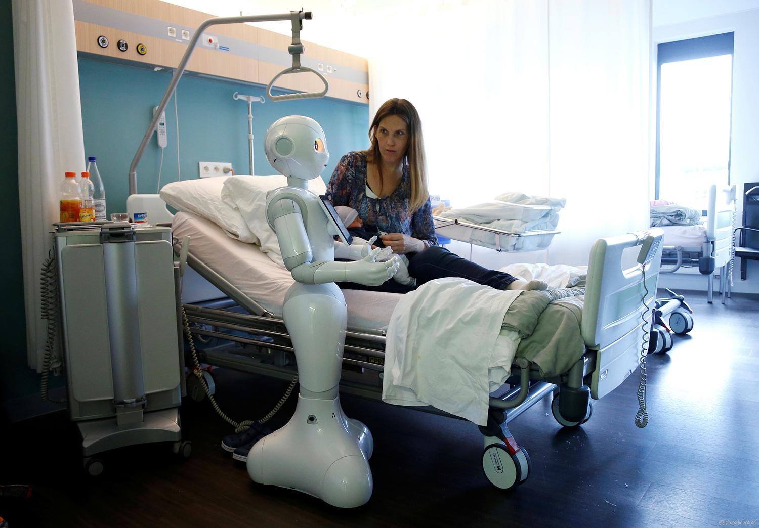 New recruit "Pepper" the robot, a humanoid robot designed to welcome and take care of visitors and patients, stands next to a mother and her new born baby at AZ Damiaan hospital in Ostend, Belgium June 16, 2016. REUTERS/Francois Lenoir - RTX2GKOD