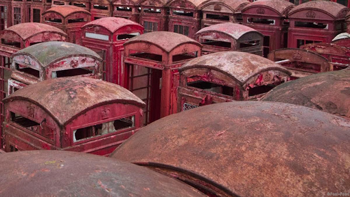 PIC FROM NICOLAS RITTER/MERCURY PRESS (PICTURED: Telephone boxes at the telephone box graveyard in Surrey) - - From bicycles to tanks and warships these are the worlds most bizarre graveyards for abandoned vehicles. This series of photos taken of places where once loved and cherish vehicles, telephone boxes and statues have been laid to rest. Eerie sites of overgrown and deserted car parks, stacked up buses and military tanks are just a few examples of these spooky graveyards. SEE CATERS COPY