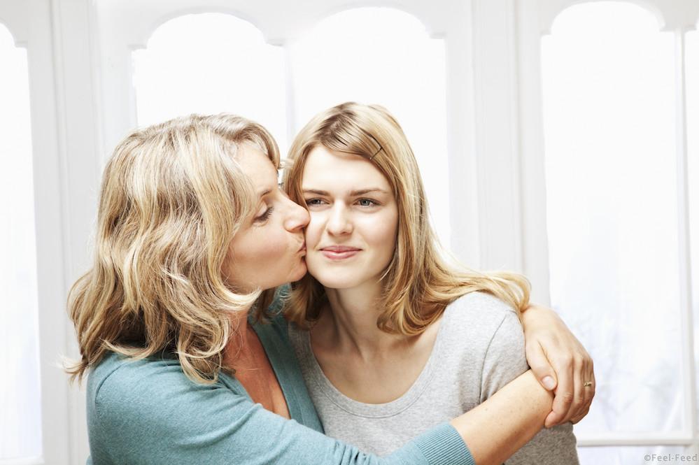 mother kisses embarrassed teenage daughter