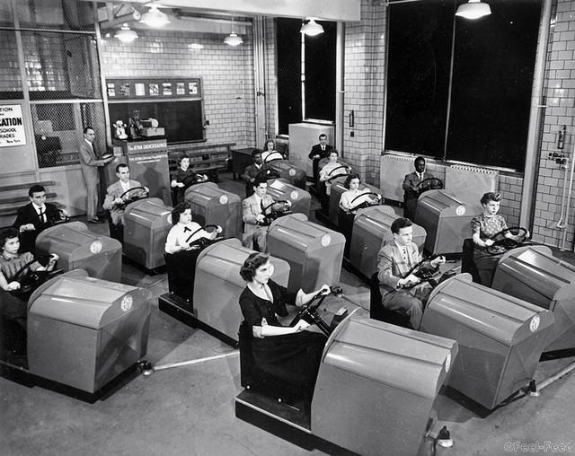 March 1953: Students at Brooklyn High School in New York learn to handle the controls of a car and experience simulated traffic conditions flashed onto a screen by means of projected film, using the Aetna Drivotrainer. (Photo by Keystone Features/Getty Images)