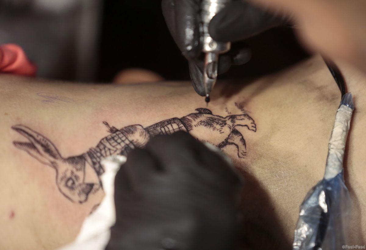 A tattoo artist works on a woman's torso during Expo Tattoo, an annual festival celebrating tattoo art, in Guatemala City, June 28, 2014. REUTERS/Jorge Dan Lopez (GUATEMALA - Tags: SOCIETY) - RTR3W90I