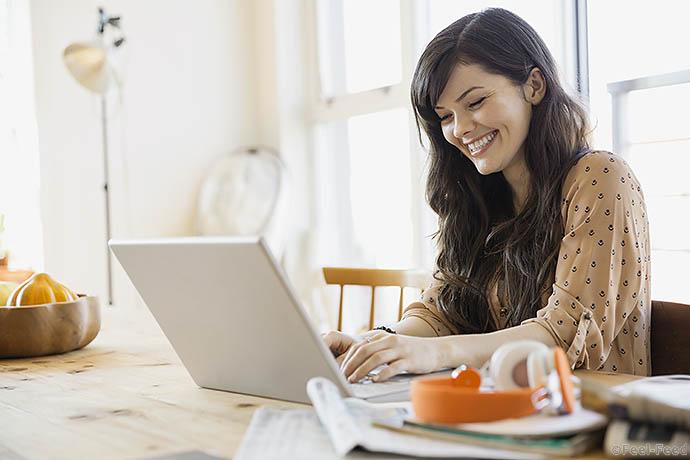 Smiling woman using laptop at table