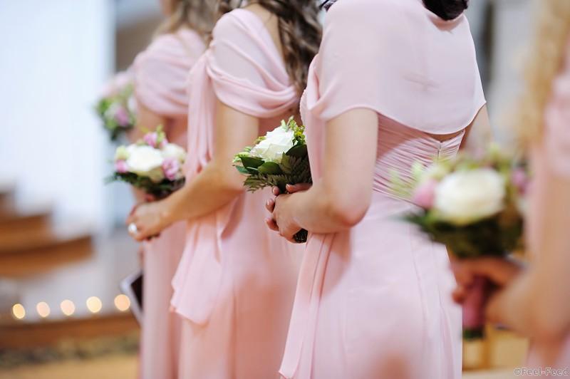 Row of bridesmaids with bouquets at wedding ceremony
