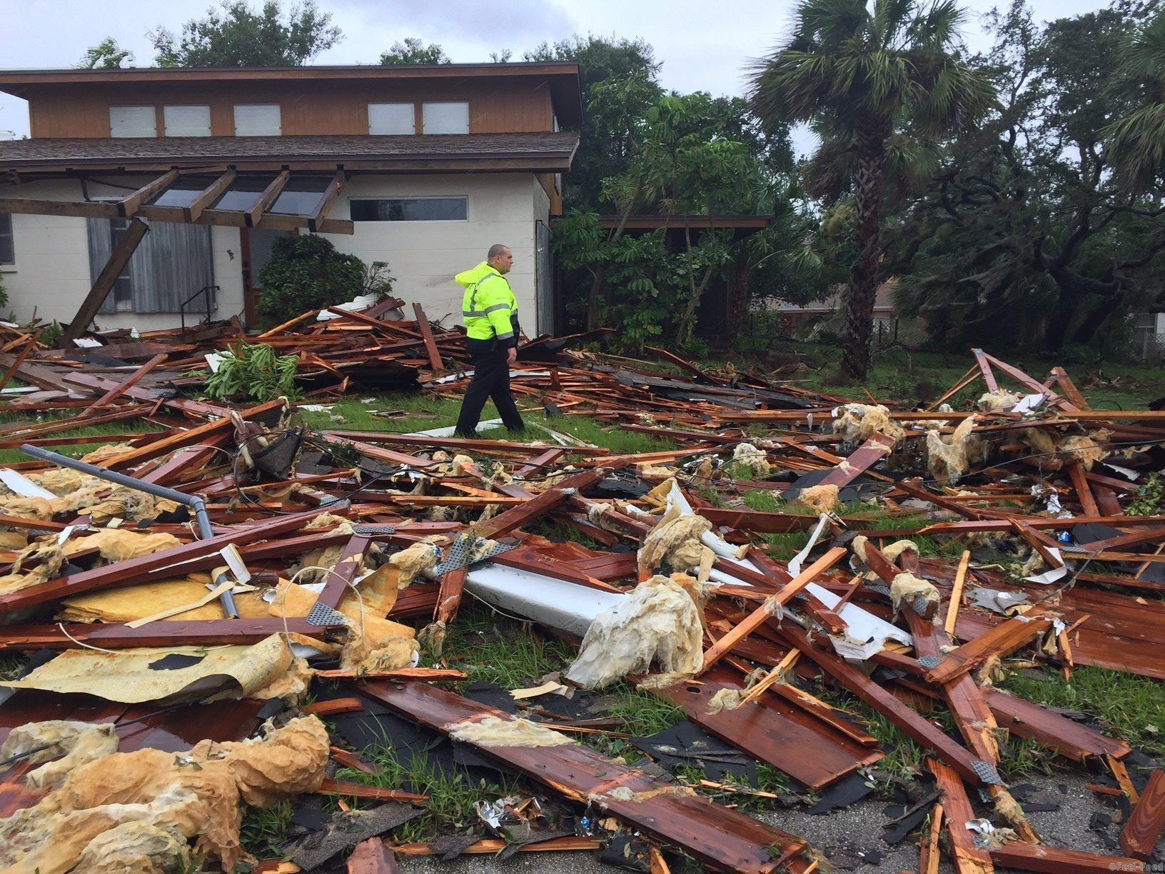 Palm Bay officer Dustin Terkoski walks over debris from a two-story home at Palm Point Subdivision in Brevard County, Fla., after a tornado touched down on Sunday, Sept. 10, 2017. (Red Huber/Orlando Sentinel via AP)