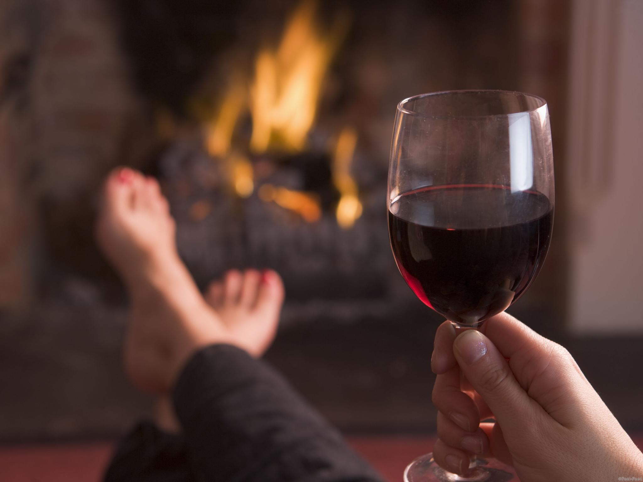 Mandatory Credit: Photo by Monkey Business Images/REX (1109309a) Model Released - Feet warming at fireplace with hand holding wine VARIOUS