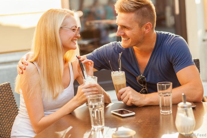 Close up of a happy couple enjoying a sidewalk cafe.