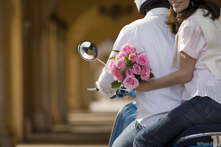 MINIMUM USAGE FEE £35. Please call Rex Features on 020 7278 7294 with any queries Mandatory Credit: Photo by Juice/REX Shutterstock (4208054a) MODEL RELEASED Couple riding on motor scooter near colonnade, woman holding bouquet of pink flowers, looking over shoulder, smiling, mid-section VARIOUS