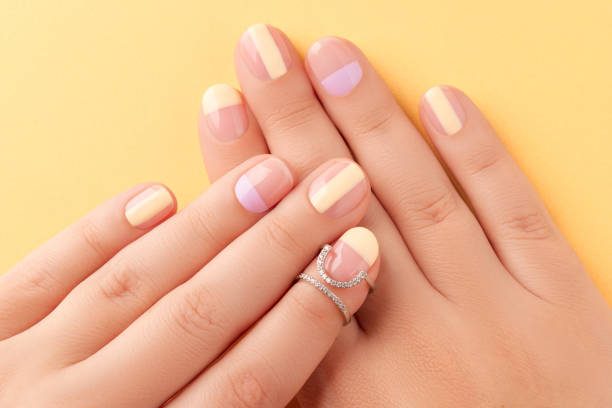 Beautiful females hands with manicure on yellow background. Trendy minimal spring summer nail design. Wellness spa beauty salon concept